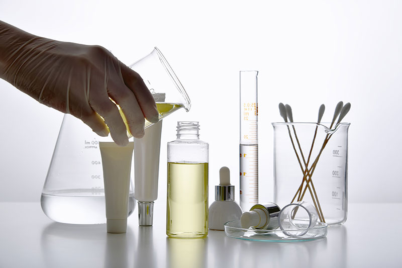 Regulatory Compliance Image shows various skin care bottles and products in a laboratory environment