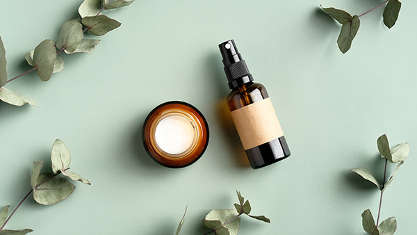Contact page image for private label skincare manufacturer Cosmetic solutions shows a skin care bottle and cream formula on a floral background